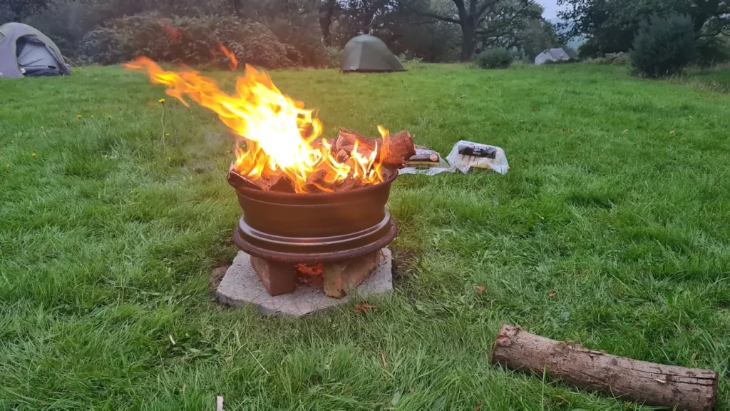 A campfire burning at dusk on the campsite