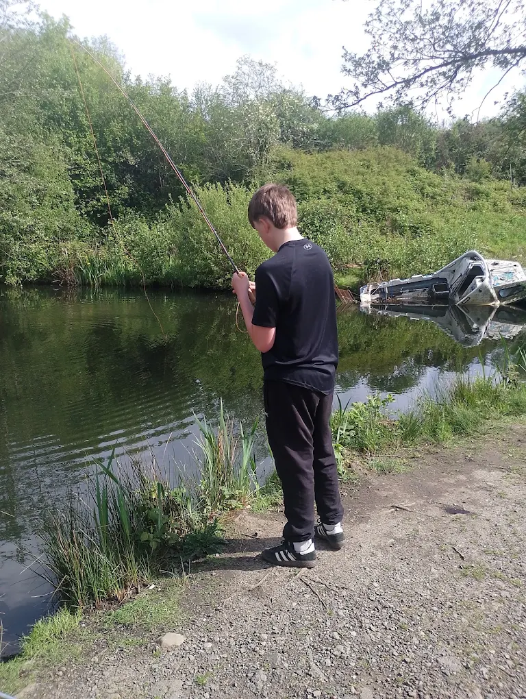 A child fishing at the water edge